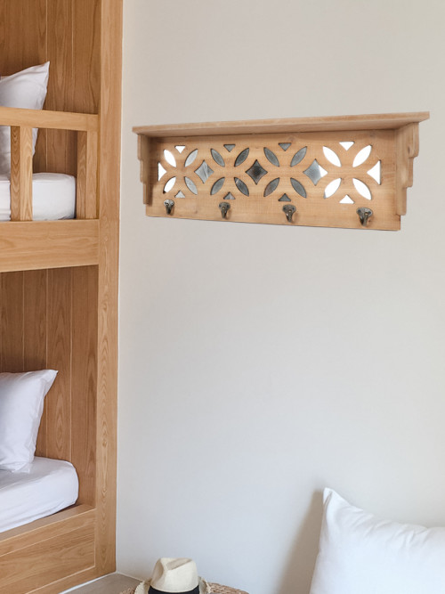 Wooden shelf decorated with mirrors and metal hangings