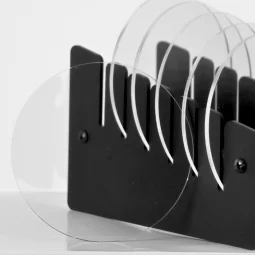 A set of 6 transparent cup coasters with a black stand